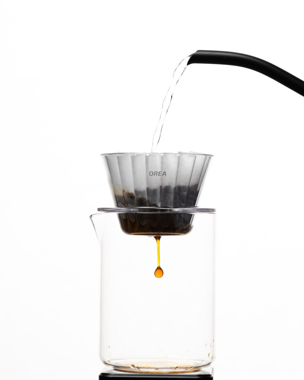 Gota de café escorrendo do filtro para a jarra de vidro enquanto a água é despejada