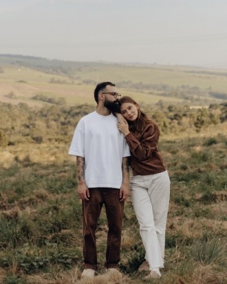 Matheus e Ana, família missionária, em um campo ao entardecer